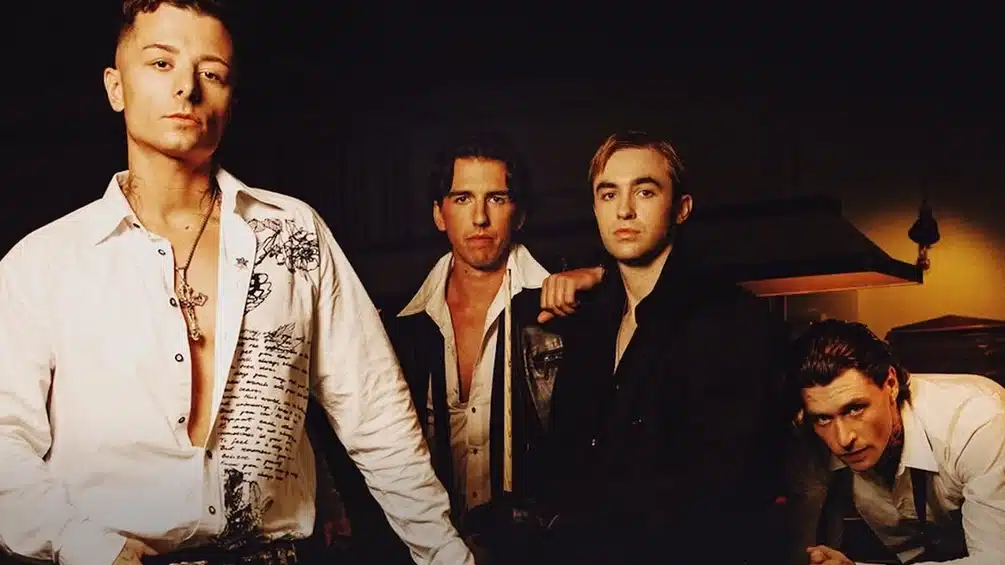 Josh Baker, KETTAMA, and Prospa pose together in a dimly lit room in a promotional photo for Embrace LDN 2027.